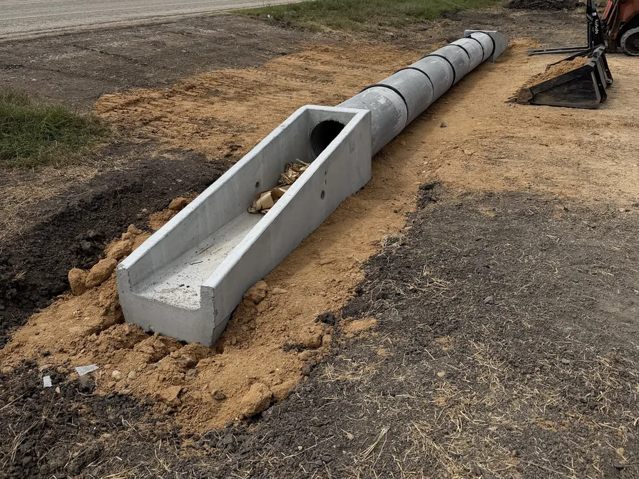 Concrete culvert pipe and end section set beside a road, culvert installation