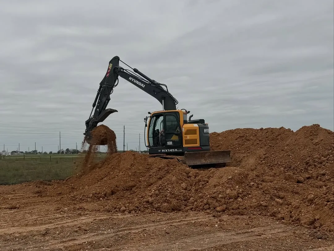 Excavator moving dirt on a large pile, dirt work