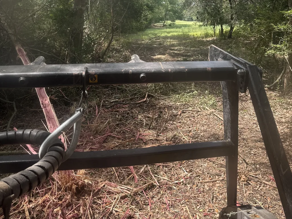 Mulching head frame seen from the cab on a fresh trail through the brush, forestry mulching