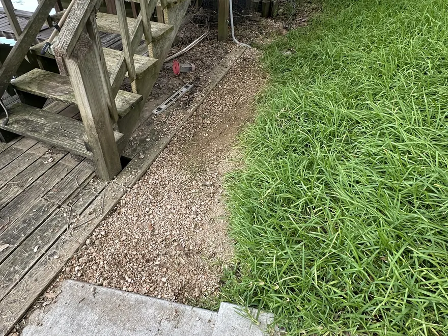 Washout beside a wood bulkhead backfilled with crushed granite, French drain installation