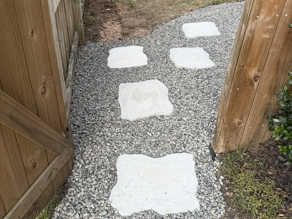 Finished French drain under gravel and stepping stones in a side yard, French drain installation