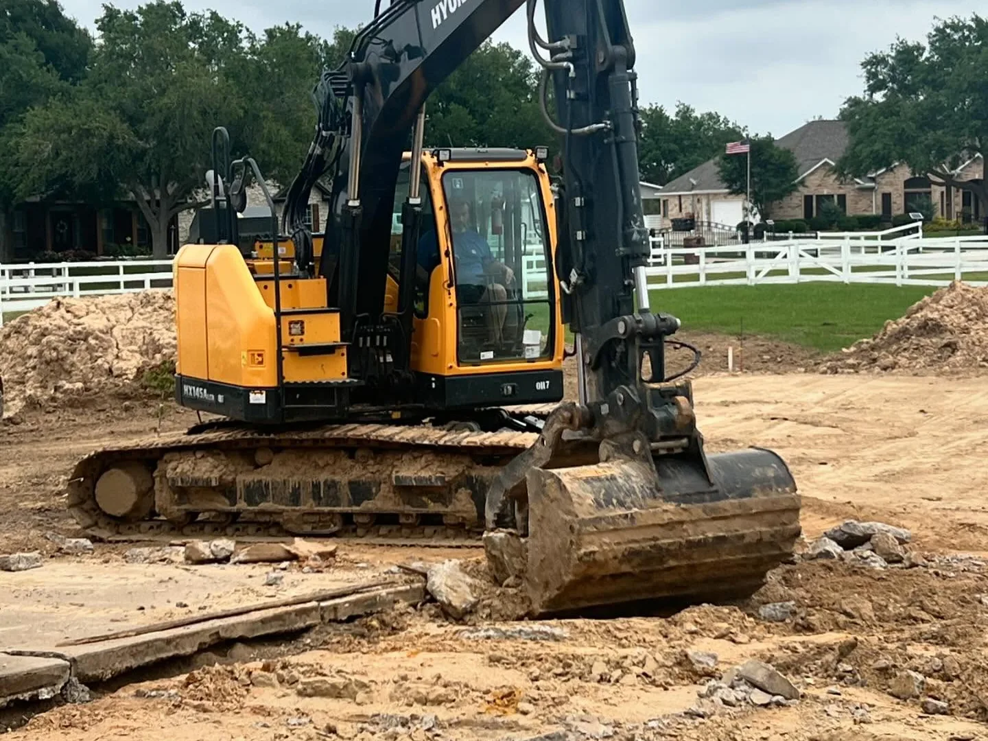 Excavator breaking out old concrete, house demolition