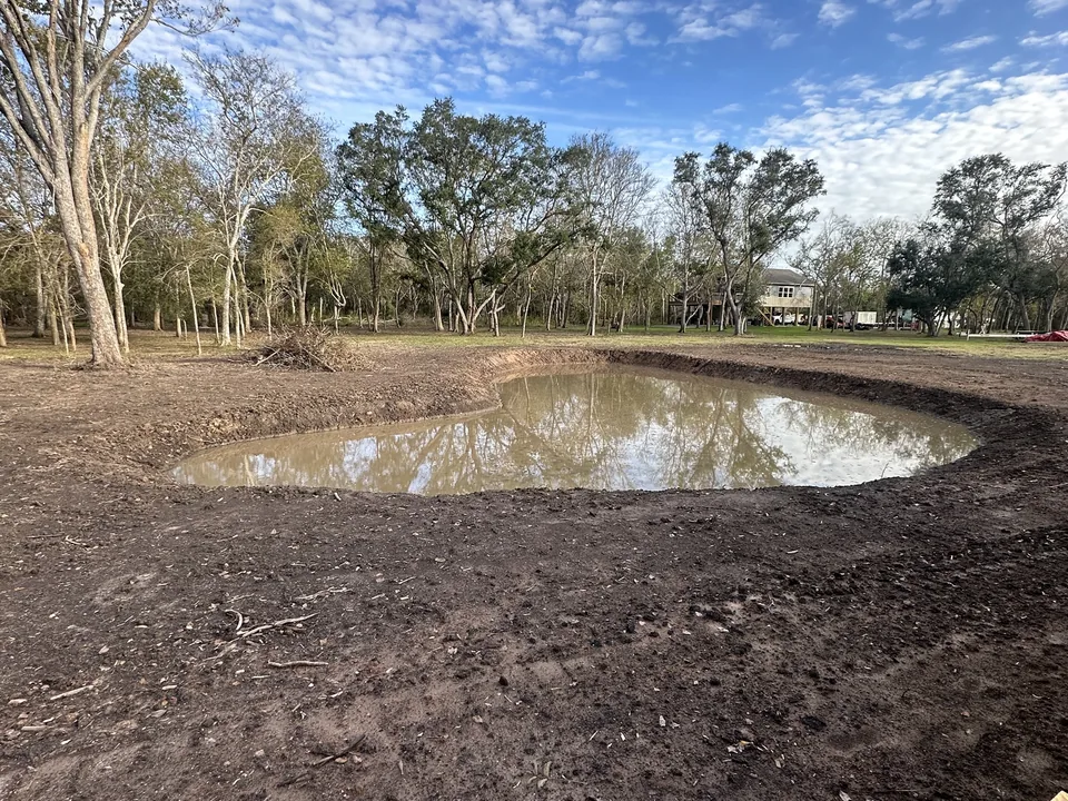 New pond holding water after rain with clean dirt banks, pond construction